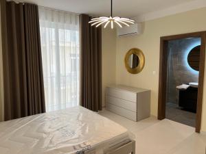a bedroom with a bed and a mirror and a window at Superb 3 Bedroom Apartment in Gzira Promenade in Il-Gżira