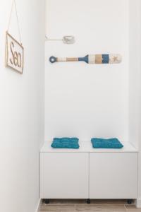 a white cabinet with two blue cushions on it at La barca apartments in Bečići