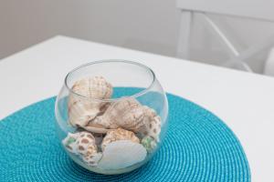 a glass vase filled with shells on a table at La barca apartments in Bečići