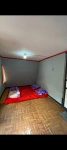 a small room with a red bed in the corner at Penginapan segitiga in Bandung