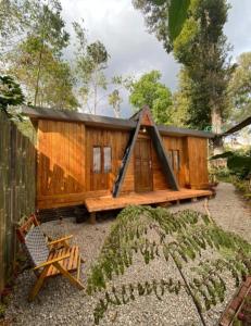a wooden cabin with a fence and a chair at Penginapan segitiga in Bandung +10 photos