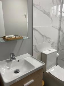 Baño blanco con lavabo y aseo en Apartamento El Nogal 2, en Tui