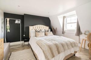 Un dormitorio con una cama grande con una pared de acento negro en The Snug Penthouse, en Sittingbourne