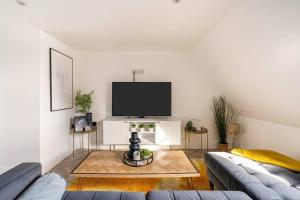 The Snug Penthouse في سيتينغبورن: غرفة معيشة مع أريكة وتلفزيون بشاشة مسطحة