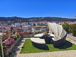 a balcony with a couch and a table on grass at Apartment Luna Tossa De Mar 5mins walking to the beach with sea and castle view big terrace in Tossa de Mar
