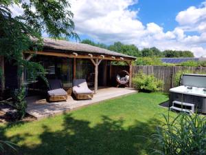 a gazebo with two chairs and a table in a yard at Buitengewoon Overnachten in Terheijden +29 photos