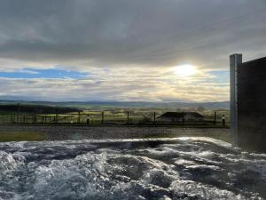 a tub filled with water with the sun in the background at Badger's Sett in Bathgate