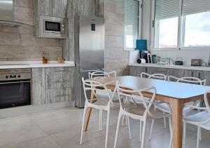 a kitchen and dining room with a table and chairs at Ría Vale 1 in Santa Marta de Magasca