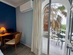 a room with a desk and a balcony with a window at Tavira Garden Oasis in Tavira