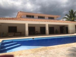 a house with a swimming pool in front of a house at VILLA GUAVABERRY n in Paraíso