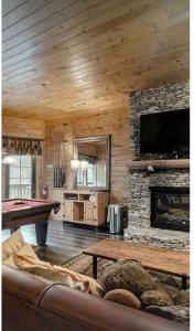 a living room with a pool table and a fireplace at Beautiful 6 bdr cabin with hot tub in the Smokies! in Pigeon Forge