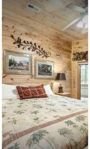 a bedroom with a large bed in a log cabin at Beautiful 6 bdr cabin with hot tub in the Smokies! in Pigeon Forge