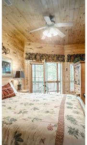 a bedroom with a large bed and a ceiling fan at Beautiful 6 bdr cabin with hot tub in the Smokies! in Pigeon Forge