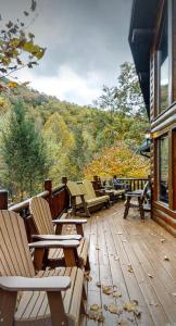 a group of chairs sitting on a wooden deck at Beautiful 6 bdr cabin with hot tub in the Smokies! in Pigeon Forge