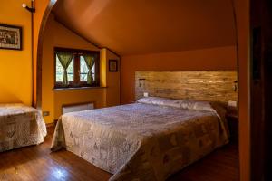 GiavenoにあるB&B Pian Savinの木製の壁のベッドルーム1室(ベッド2台付)