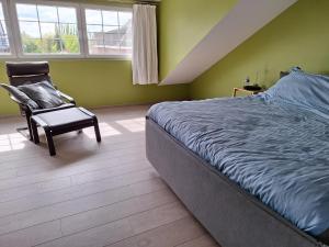 sypialnia z łóżkiem, krzesłem i oknami w obiekcie Kapstertje w mieście Grimbergen