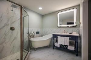 a bathroom with a tub and a sink and a mirror at Westin Sacramento in Sacramento