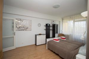 una camera da letto con un letto con due cuscini rossi sopra di Beach Apartman a Zamárdi