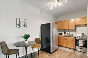 cocina con nevera de acero inoxidable y mesa en 1BR Tranquil Hyde Park Apartment - Harper 202 & 402 rep en Chicago