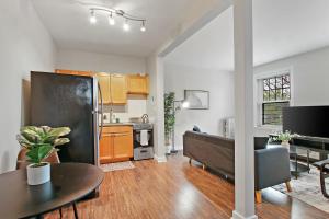1BR Tranquil Hyde Park Apartment - Harper 202 & 402 rep في شيكاغو: مطبخ وغرفة معيشة مع ثلاجة سوداء