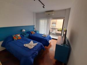 1 dormitorio con 2 camas y TV. en Turismo Apart Palermo en Buenos Aires