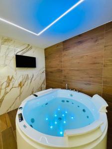 a jacuzzi tub in a room with a tv at Suite169 Gold in Bari