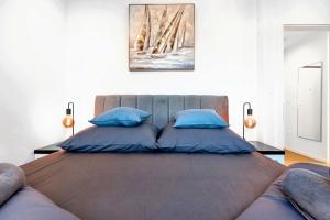 a bedroom with a large bed with blue pillows at Nautilus Apartment II Whirlpool in Novalja +43 photos