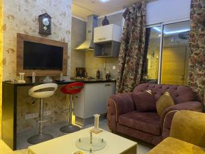 uma sala de estar com um sofá e uma televisão em Appartement élégant em Sousse
