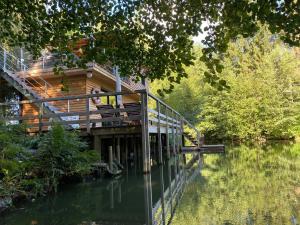 una casa sentada en un puente sobre un cuerpo de agua en Les Cabanes de Koad'dour - séjour SPA dans les arbres en Les Portes du Coglais