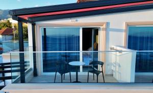 a glass balcony with a table and two chairs at Ionian Terrace in Himare