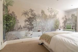 The Snug Den في Kent: غرفة نوم جدارية من الأشجار وسرير