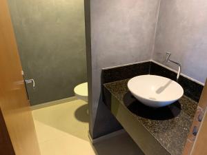 łazienka z toaletą i umywalką na ladzie w obiekcie Royal Duplex Umarizal w mieście Belém