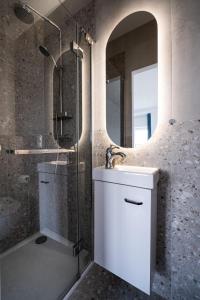 a bathroom with a sink and a shower with a mirror at Apartament Morze, Sarbinowo in Sarbinowo