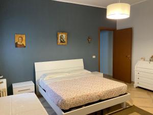 ein Schlafzimmer mit einem Bett und einer blauen Wand in der Unterkunft “da nonna Lucia” in Lequile