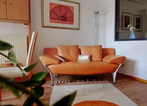 un sofá naranja sentado en una sala de estar en Ferienwohnung Der Gerber en Hilden