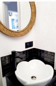 a bathroom with a white sink and a mirror at Gold Apartament in Wałbrzych