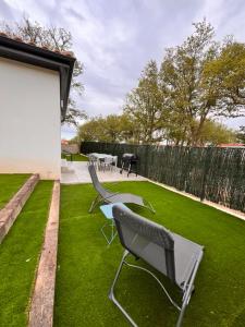 een tuin met twee stoelen en een tafel op het gras bij L'Eden des Aspres in Thuir