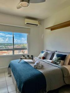 1 dormitorio con cama y ventana grande en Studio 1131 - Água-Marinha, en Ribeirão Preto