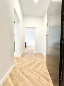 an empty room with a refrigerator and a hallway at Apartament Opolska 5 in Tarnowskie Góry