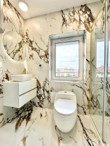 a bathroom with a white toilet and a sink at Apartament Opolska 5 in Tarnowskie Góry