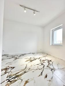an empty room with a marble floor and a window at Apartament Opolska 5 in Tarnowskie Góry