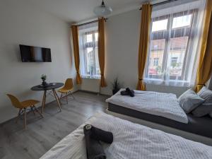 sypialnia z 2 łóżkami, stołem i 2 krzesłami w obiekcie Penzion Grand Nymburk w mieście Nymburk