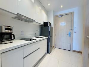 een keuken met witte kasten en een blauwe koelkast bij Cozy Studio Rawai Beach Phuket in Ban Saiyuan (1)