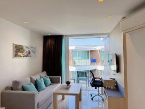 een woonkamer met een bank en een tafel bij Cozy Studio Rawai Beach Phuket in Ban Saiyuan (1)