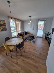 uma sala de estar com uma mesa e um sofá em Apartament Topolowa 48 em Elblag