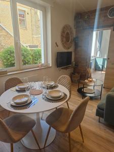a dining room with a table and chairs and a living room at Villa Leone Rénové à 500m de la Plage in Dunkerque