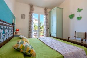 ein Schlafzimmer mit einem grünen Bett und einem Fenster in der Unterkunft La Conchiglia in Marina di Sorso