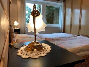una lampada su un tavolo accanto a un letto di Holiday apartment Kassler a Feldberg