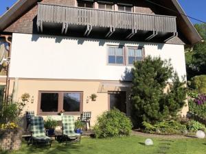 a house with two chairs in the yard at Holiday apartment Kassler in Feldberg