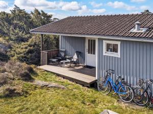uma casa azul com bicicletas estacionadas num deque em Holiday home ELLÖS II em Ellös